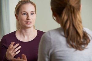 a person talks to another during alcohol addiction treatment