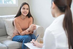 a woman talks to a therapist in a women's rehab center